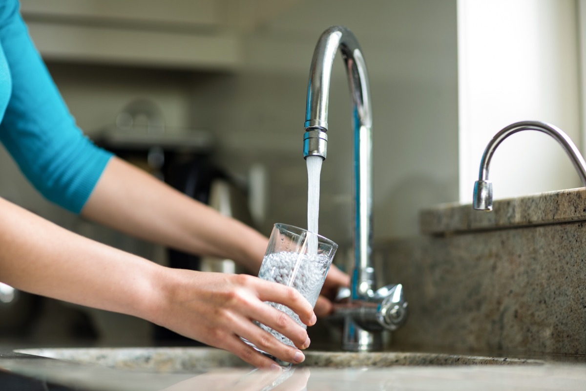 Woman getting water from sink