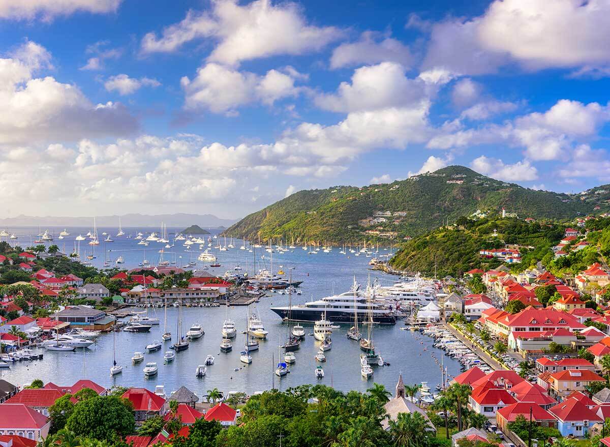 a view of the harbor, boats, and mountains of st. barts