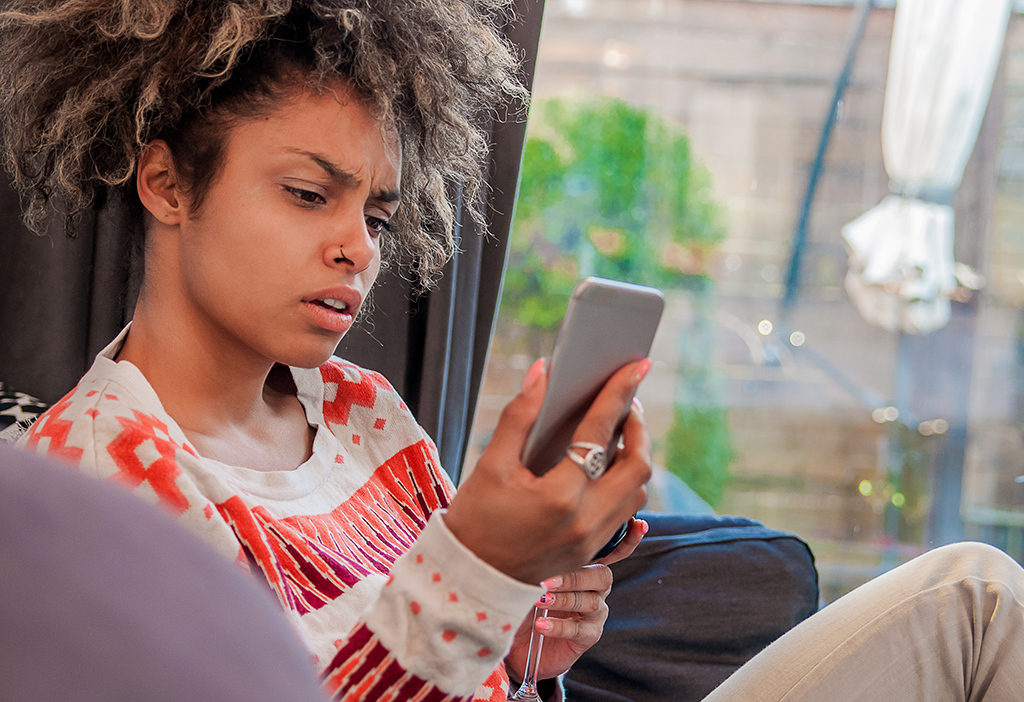 woman looks at phone shock disbelief