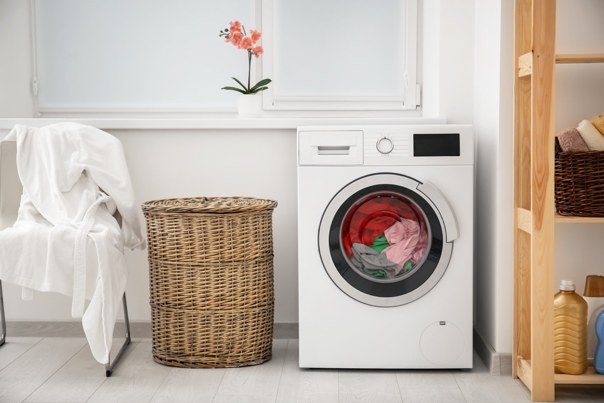 Laundry in washing machine and basket indoors - Image