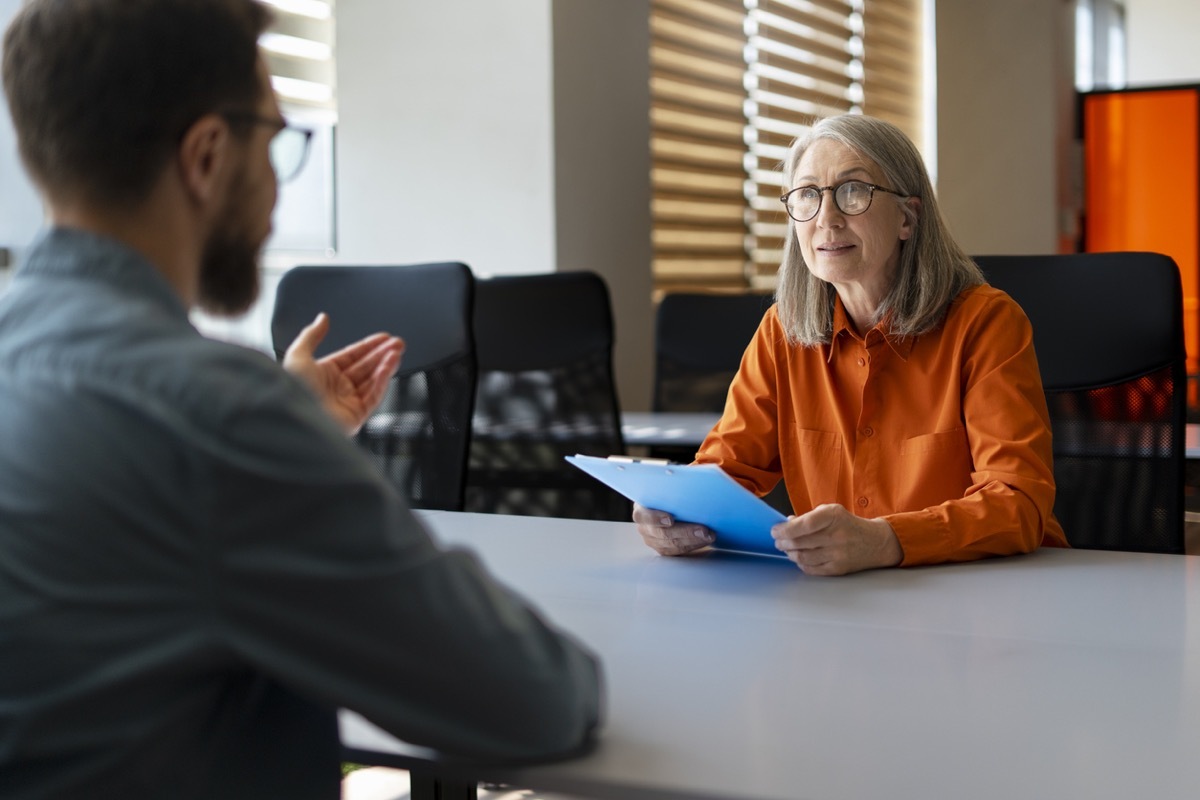 woman listening to interviewee answering a question about his challenges