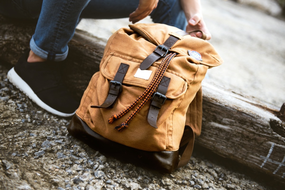 young white woman packing backpack