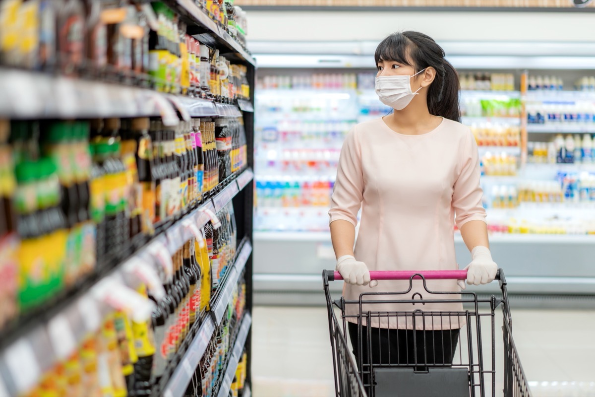 woman in grocery store shopping for sauces