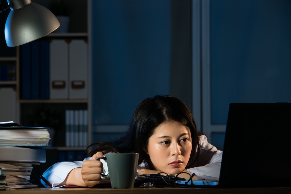 Tired woman still in office at night