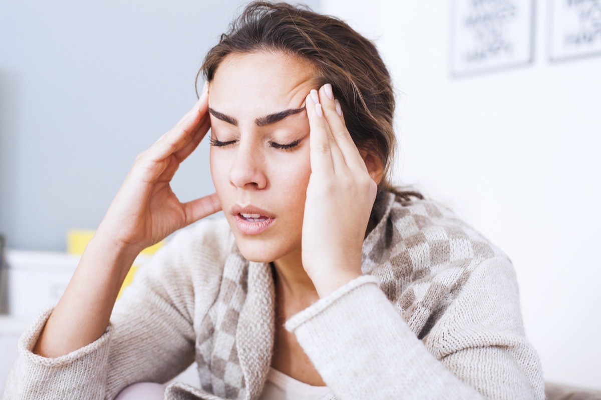 Woman with hard headache holding hands on head