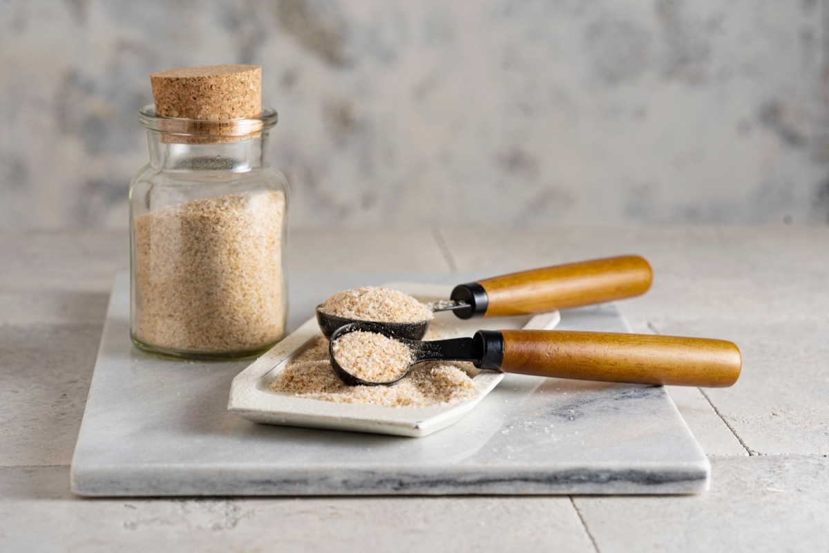 Psyllium husk on spoon soluble fiber supplement on white background. Superfood for healthy, lowers cholesterol, balances blood sugar, eases constipation, boosts weight loss. Keto, paleo low carb diet