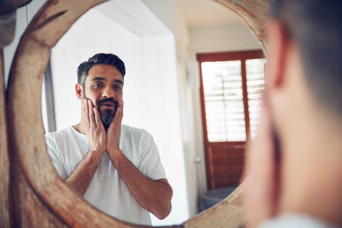 Shot of a mature man looking at his reflection the bathroom mirror