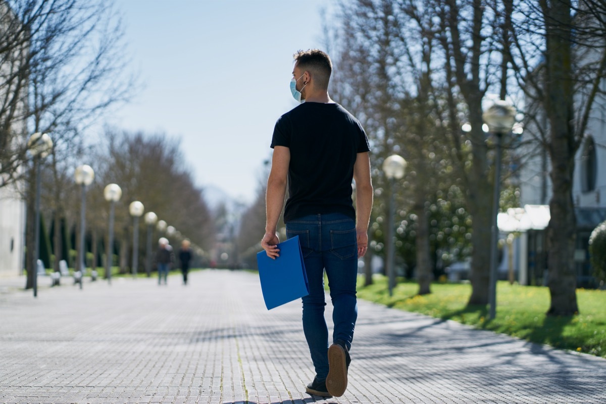 Man walking on sidewalk wearing mask