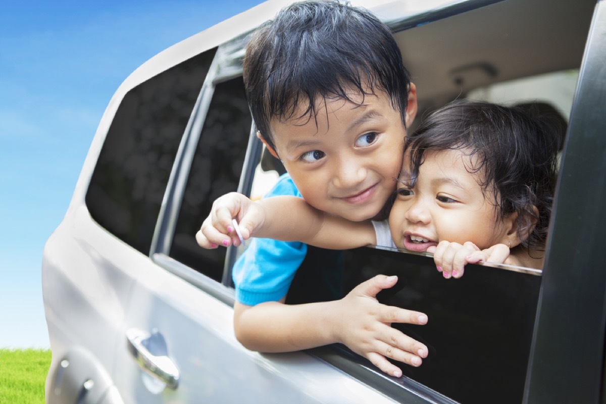 young boy and girl siblings leaning out of car window, bad parenting advice