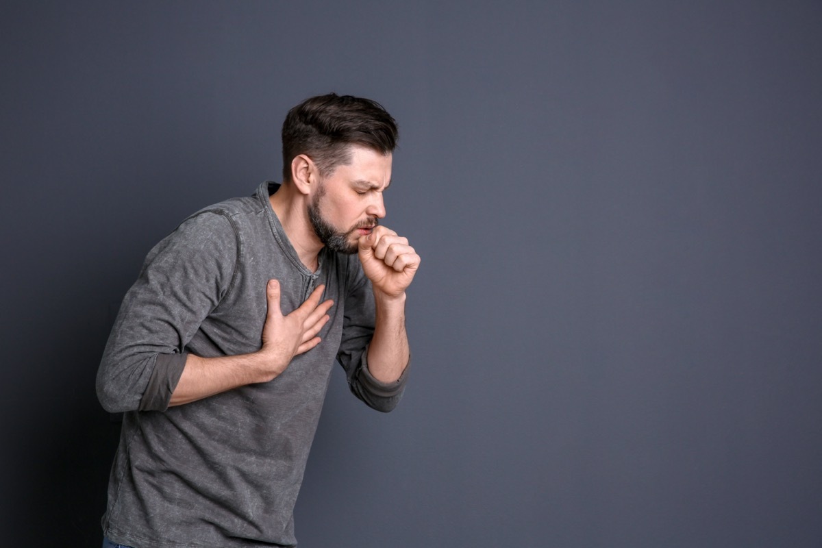 Mature man coughing on color background