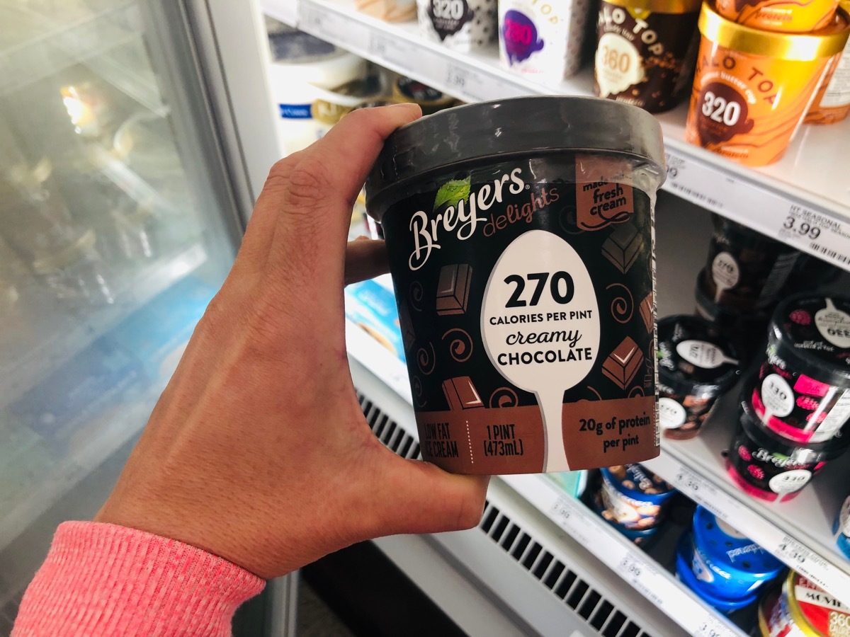 Woman buying low-calorie ice cream at the grocery store