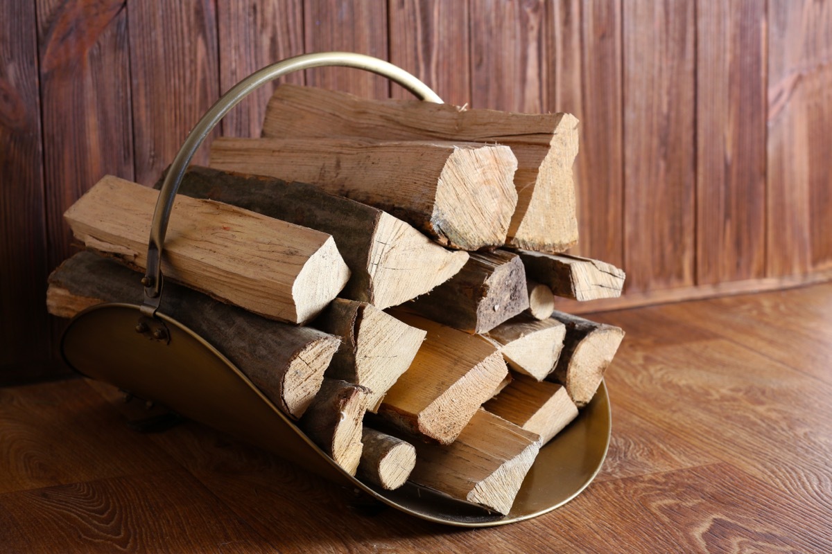 stacked firewood in metal carrier inside home