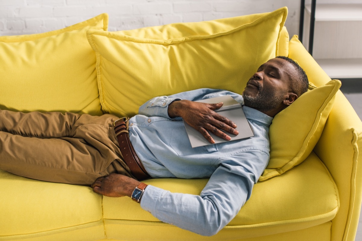 Old black man in khakis and button down napping on yellow couch perfect nap