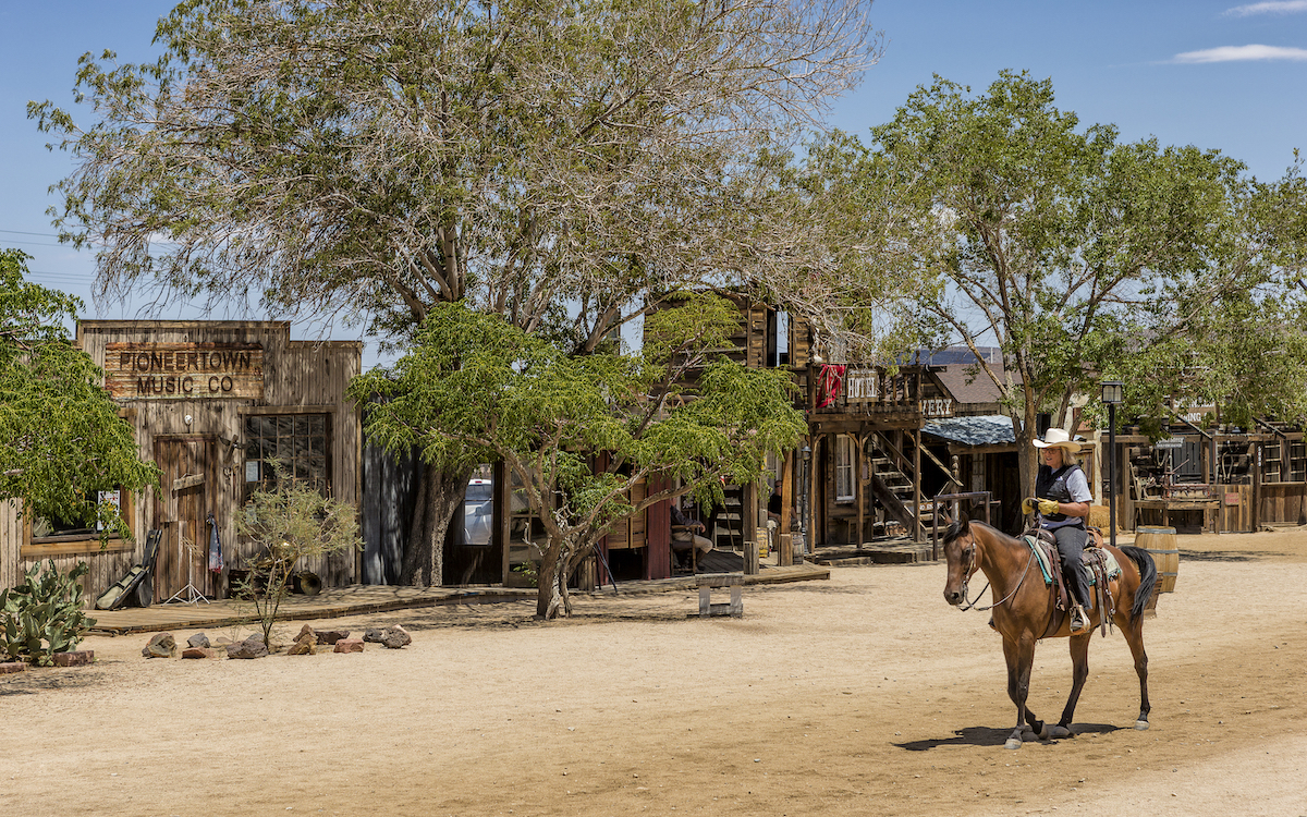 A woman riding a horse down Main Street in Pioneertown, California