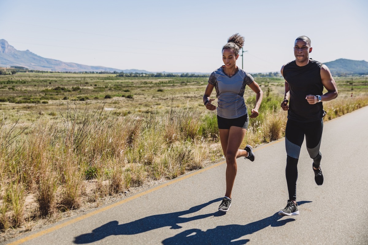 man and woman running near field, working out