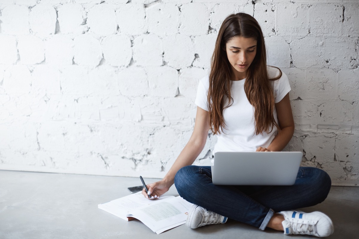 female student sitting on floor doing math problems for math jokes