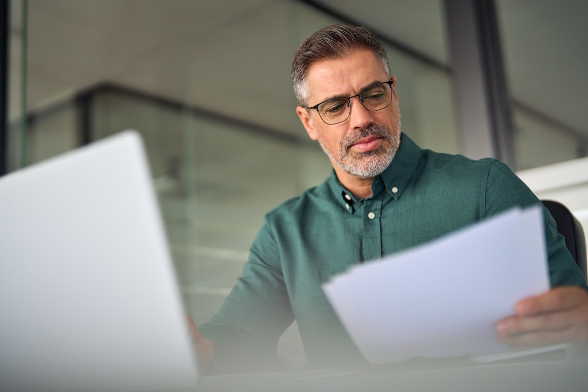 middle-aged businessman reviewing documents before annual review