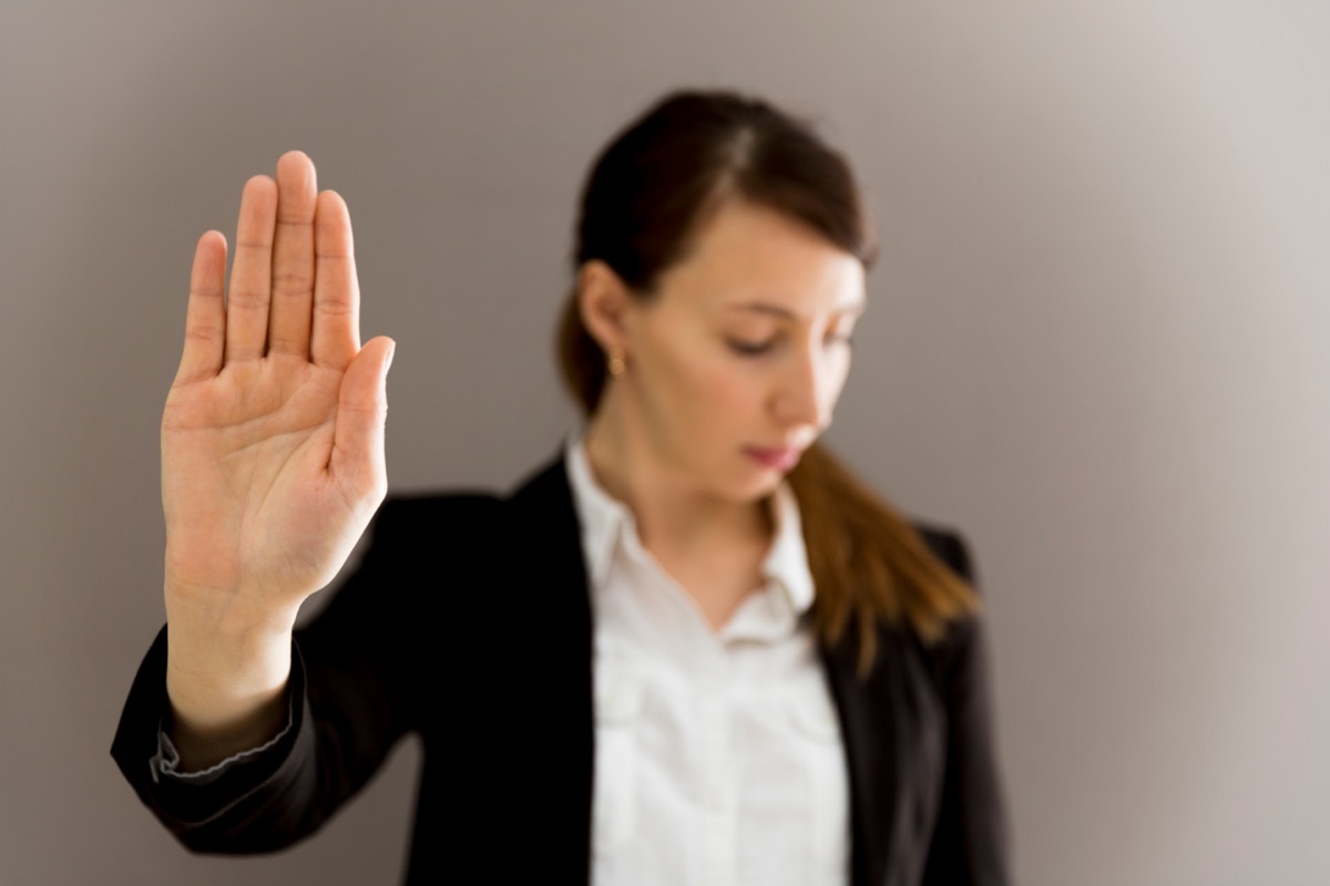 Young Woman Holding Up Hand to Stop You