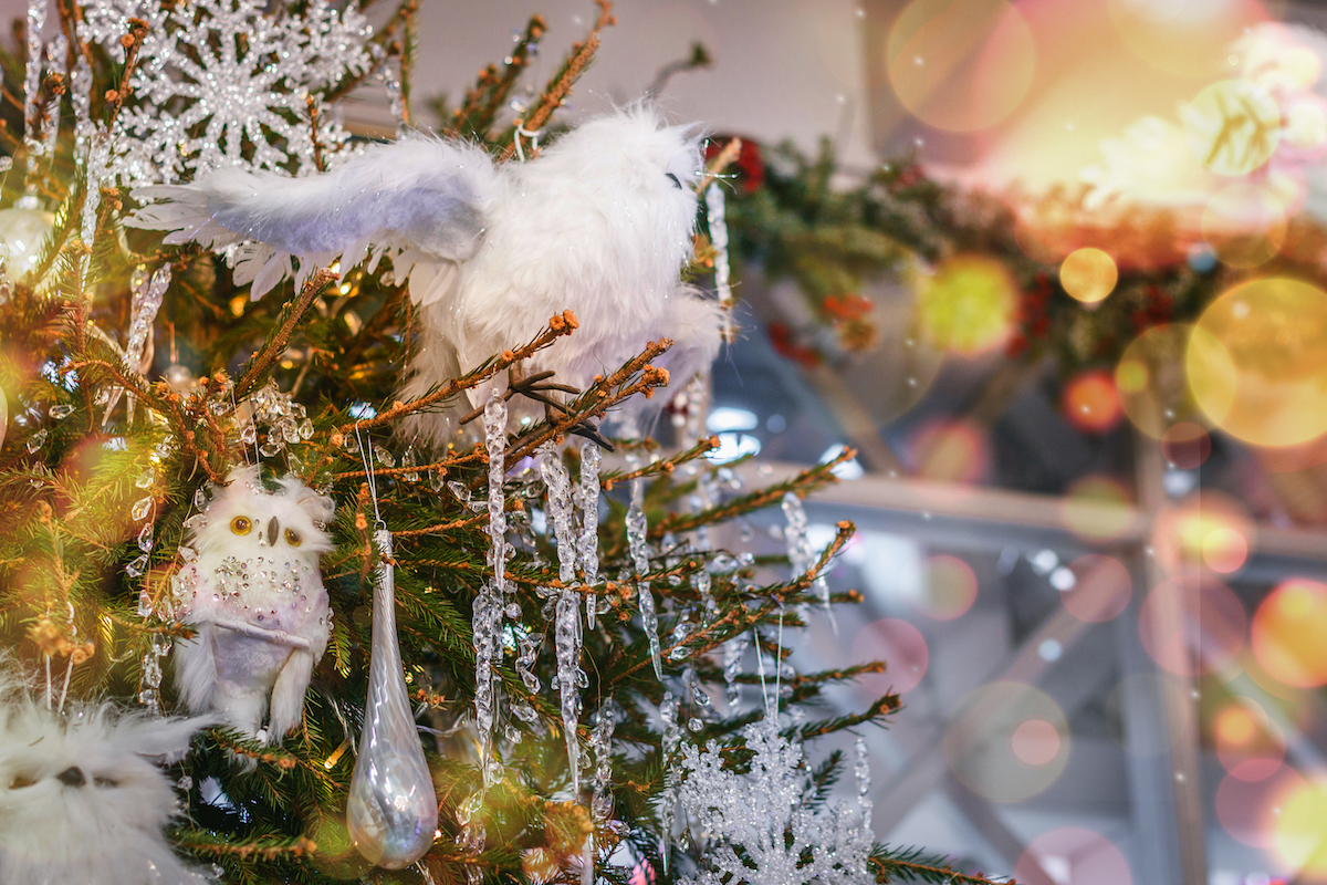 Close up of a Christmas tree decorated in icicle ornaments and white owl ornaments.