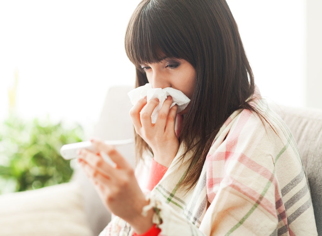 Sick woman reading temperature