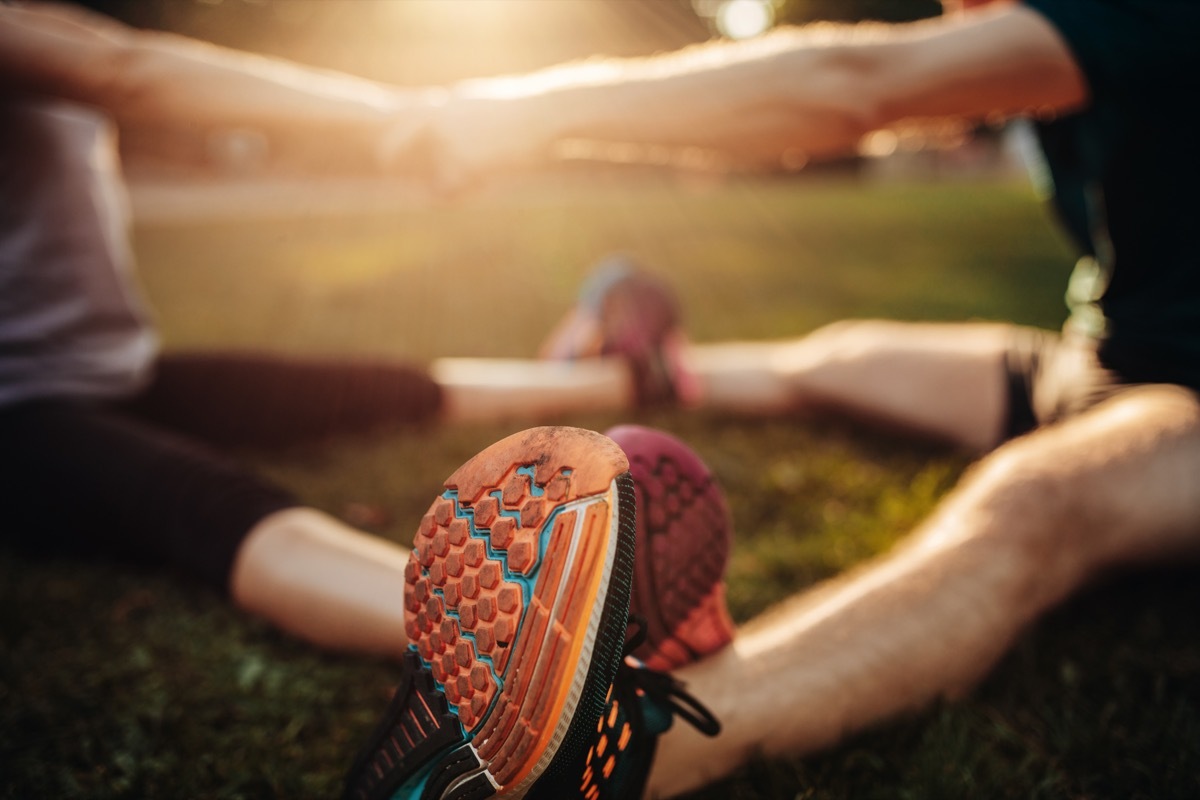 a couple stretching in a park before exercising