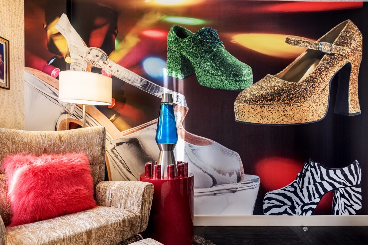 A chair next to a lava lamp and disco shoe wallpaper