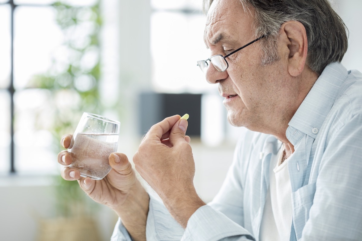 Old man taking a pill