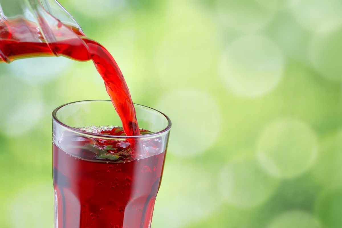 pouring cherry juice into clear glass