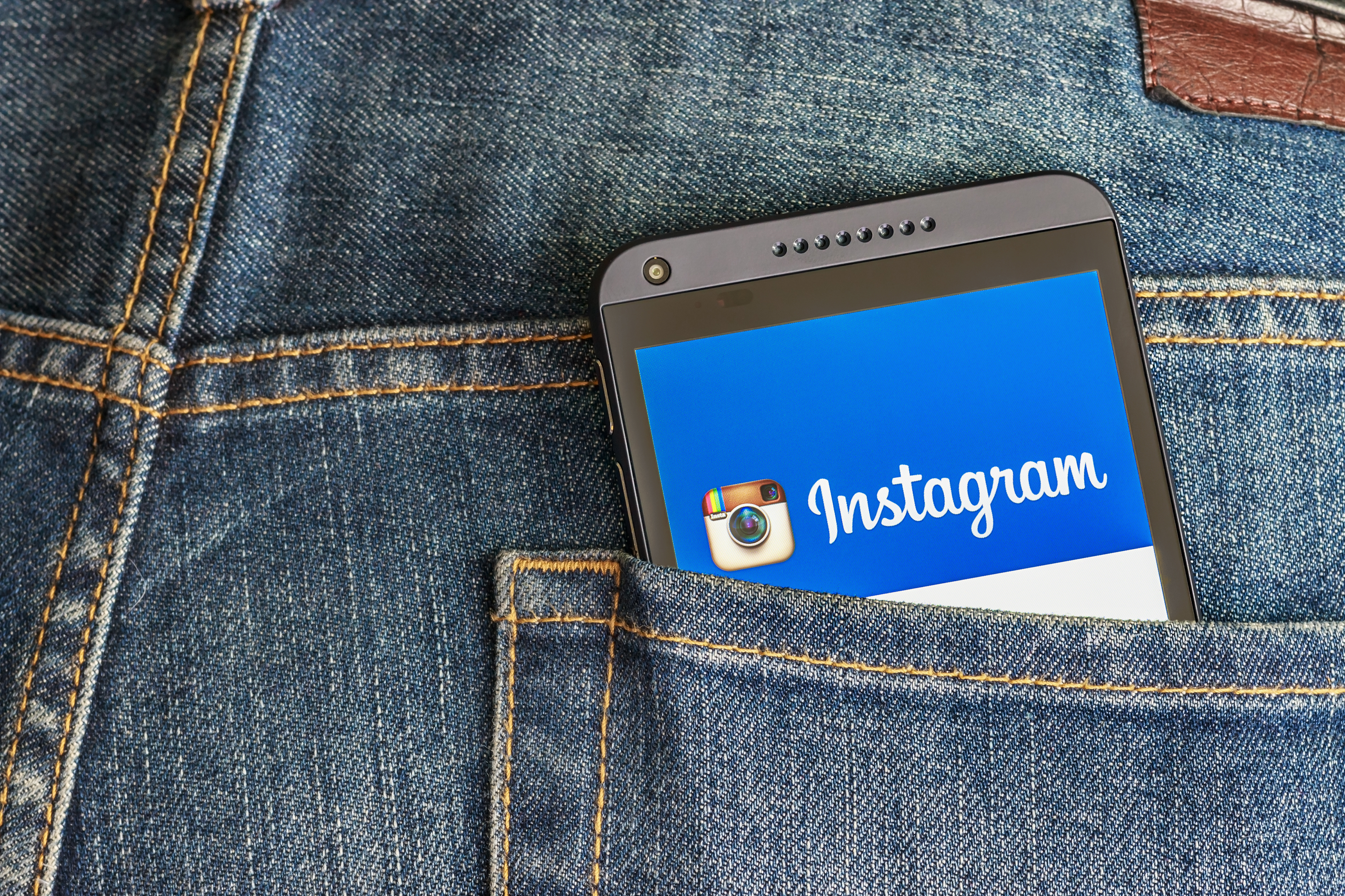 instagram app open on phone in someone's back pocket