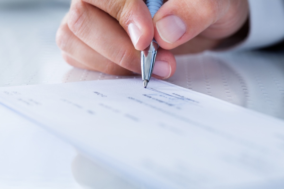 white man signing a check