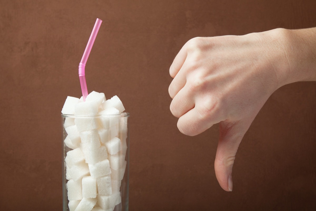 Sugar cubes in glass and hand shows thumbs down.