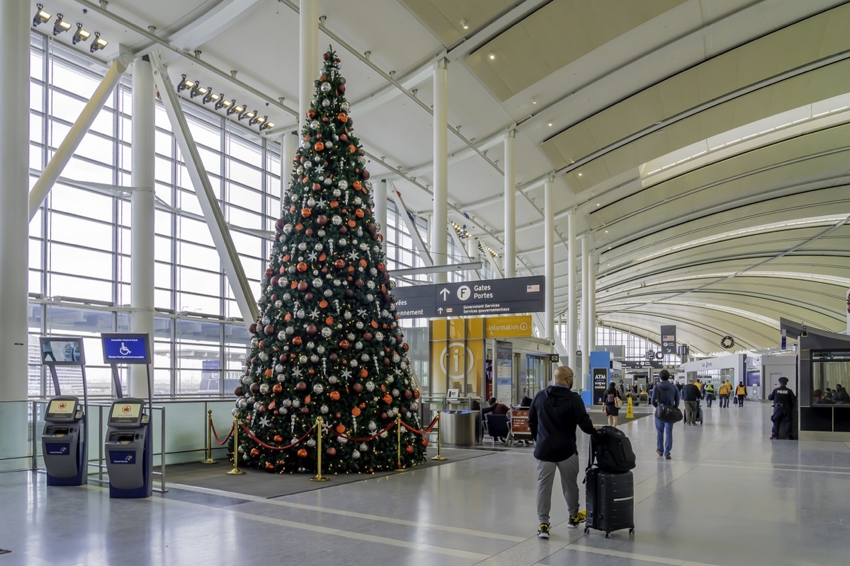 Toronto, Canada - December 7, 2019: A passenger passed by a Christmas tree at Pearson Airport in Toronto. Pearson Airport is the largest and busiest airport in Canada.