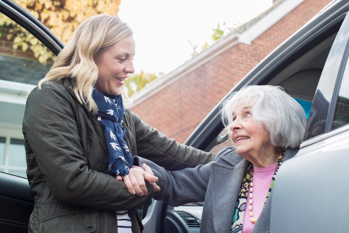 Female neighbor giving senior woman a lift In car.