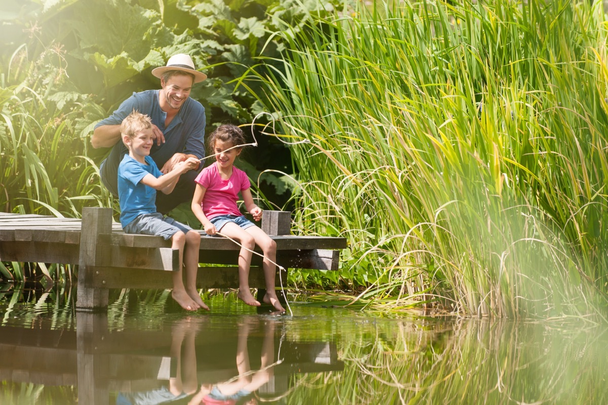 Father and children fishing on a lake