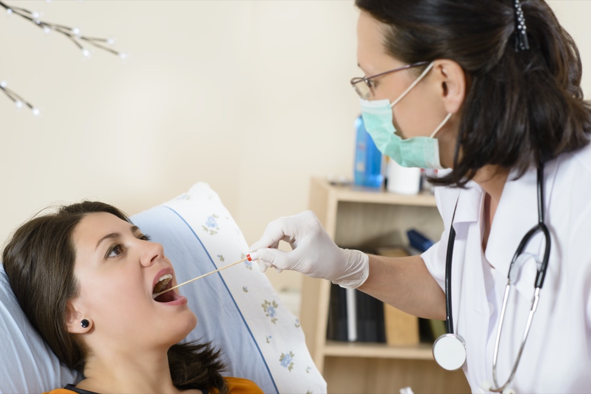 Young woman at doctor being tested for pain in the throat