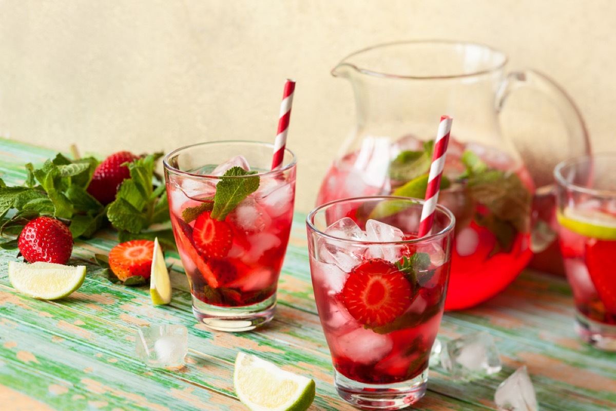 pitcher of sangria with two glass cups and striped straws