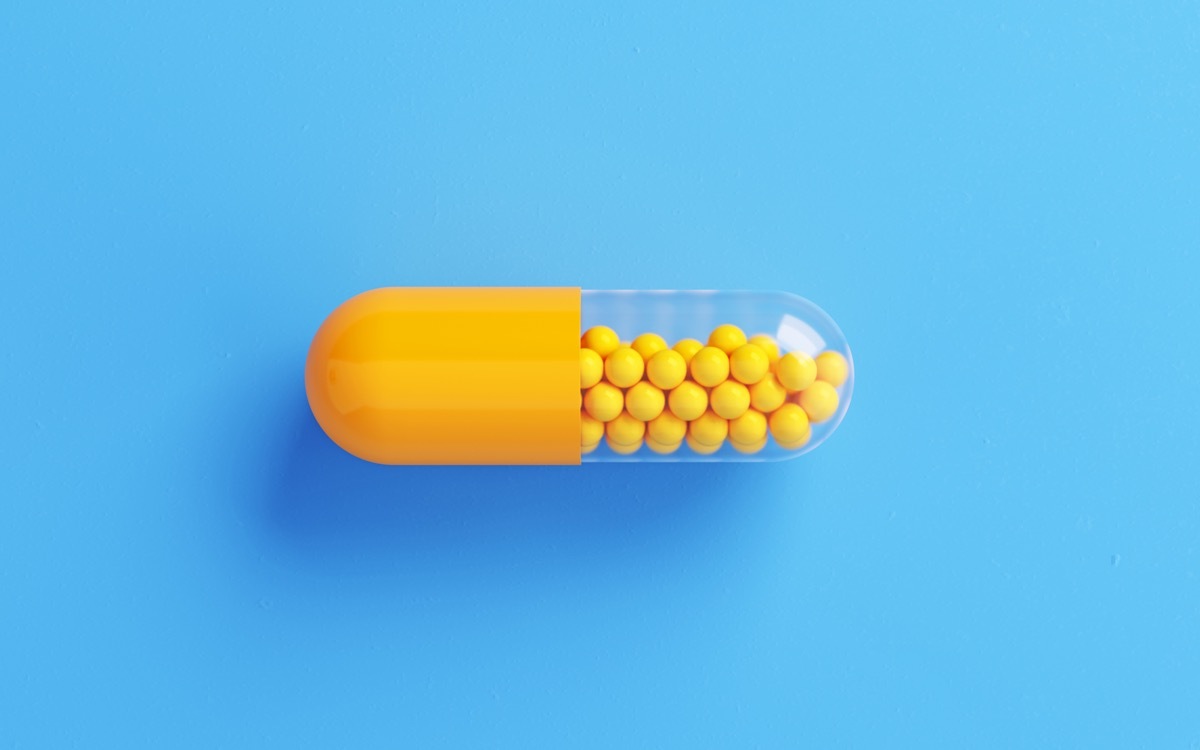 Yellow Pill bottle on Blue Background.