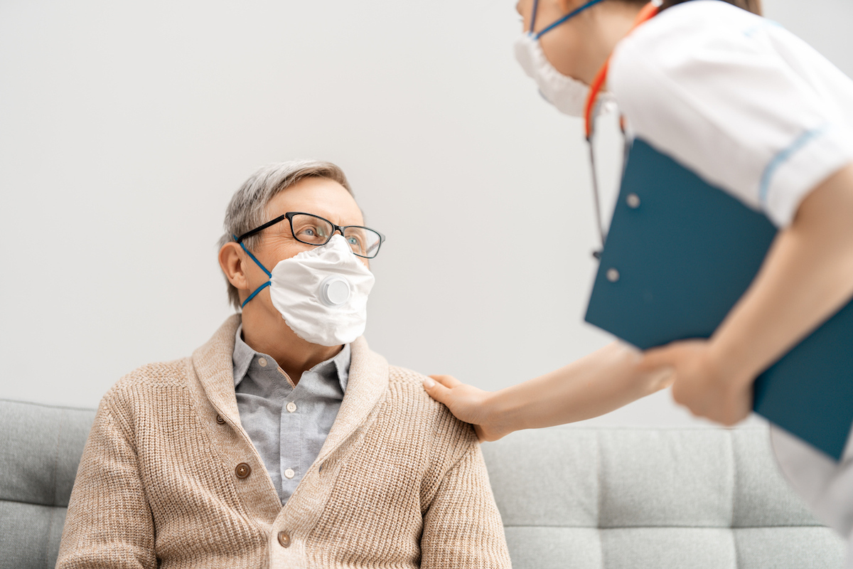 Doctor and senior man wearing face masks during coronavirus outbreak. 