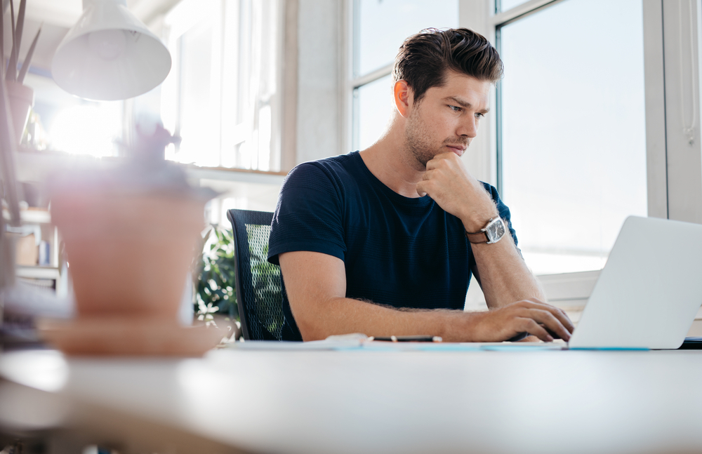 A young man using a laptop to surf the internet