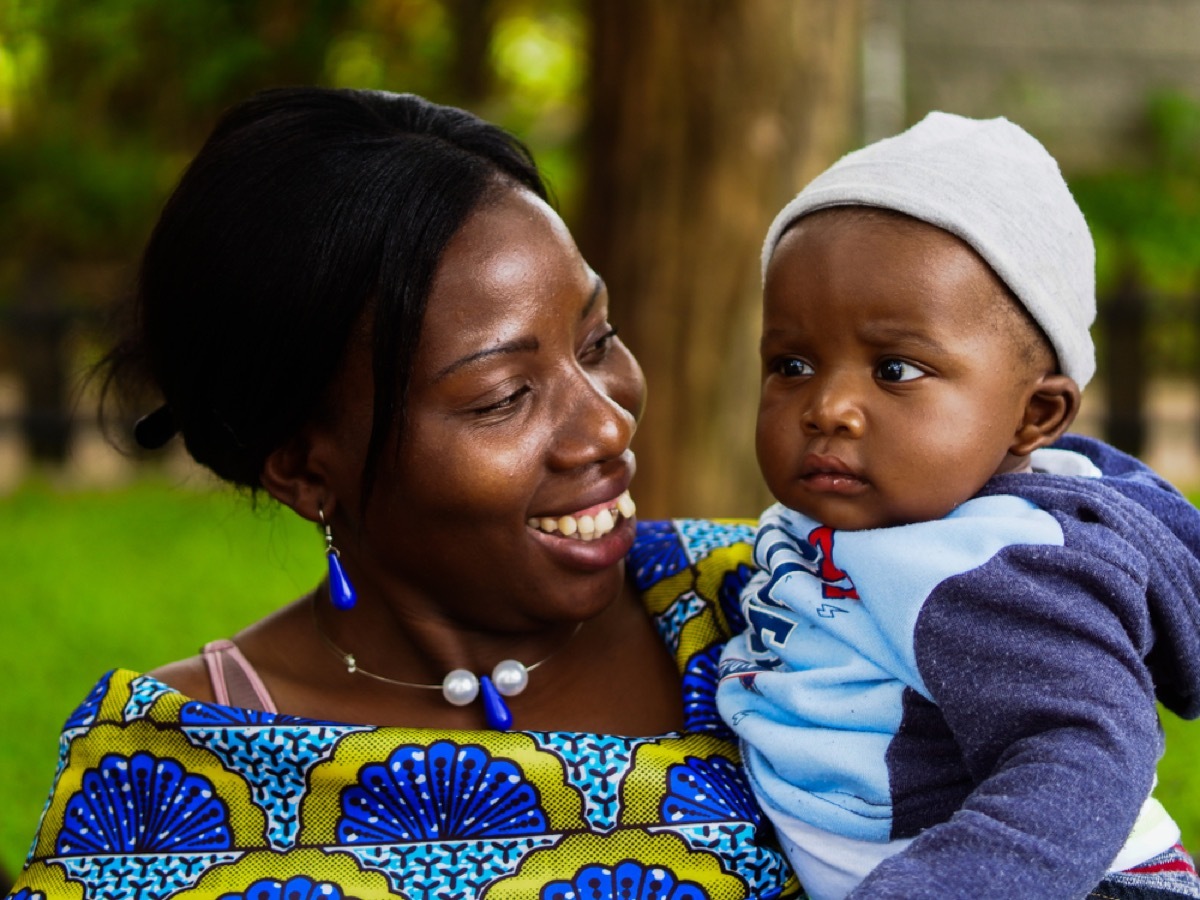 zimbabwean woman smiling at baby in her arms