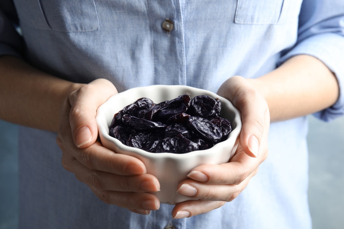 woman holding bowl of prunes