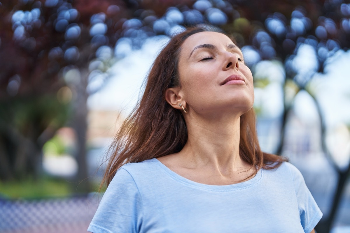 Young woman breathing at park.