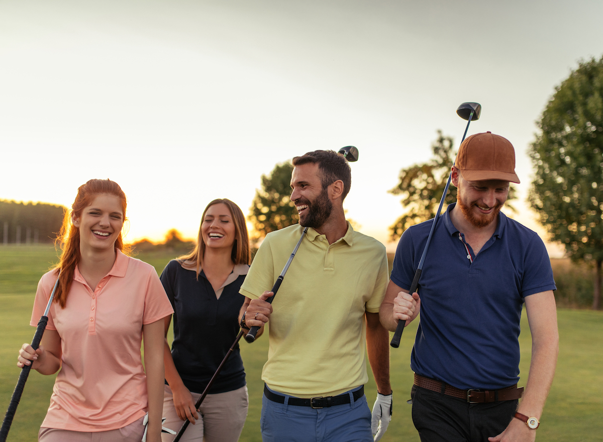 friends-walking-on-golf-course-with-clubs