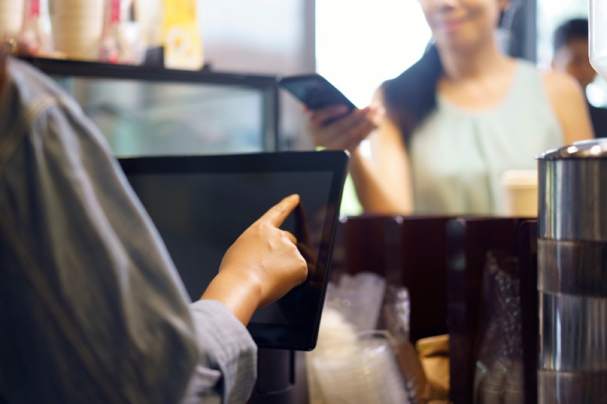 woman on phone ordering from cashier, rude behavior