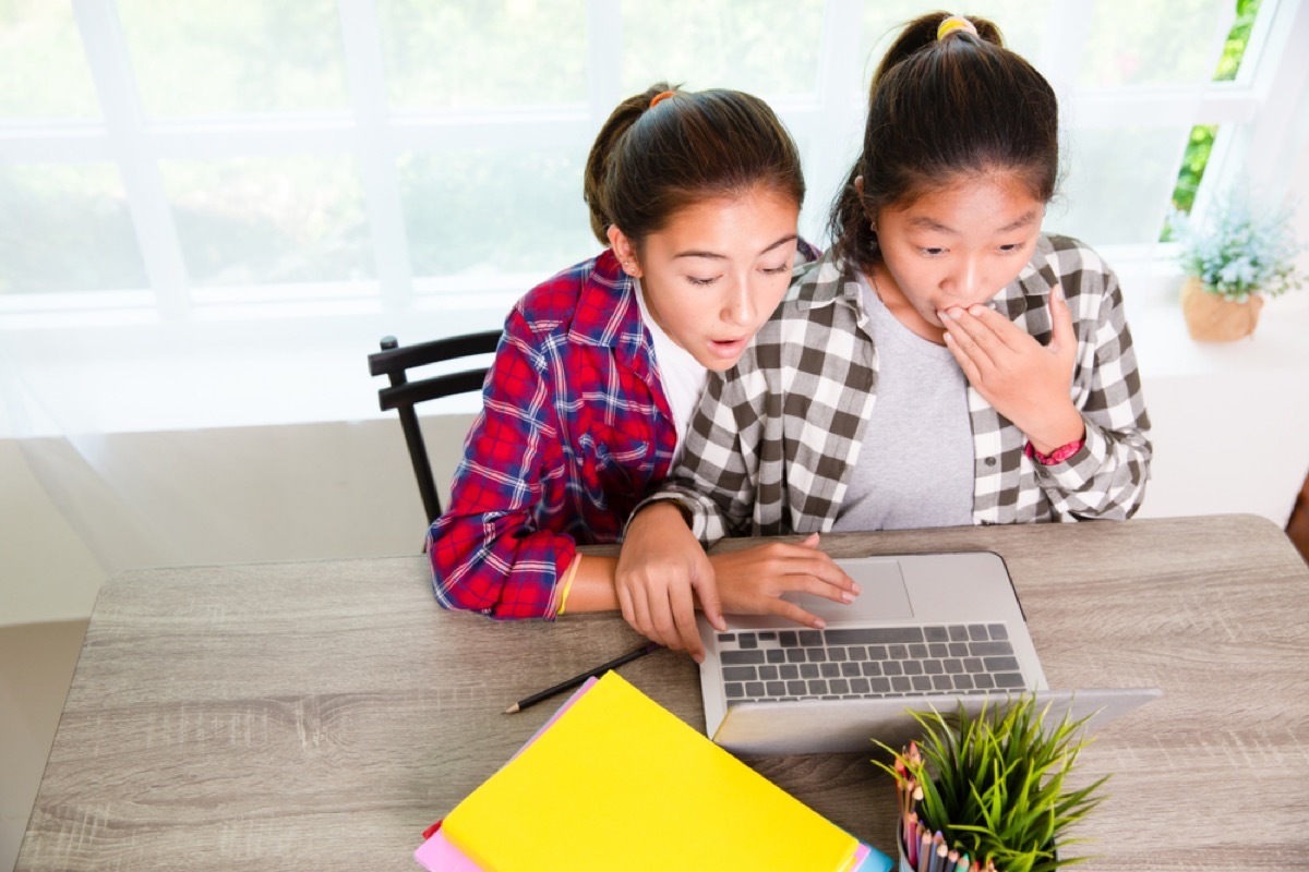 two young girls looking at laptop screen, parenting is harder