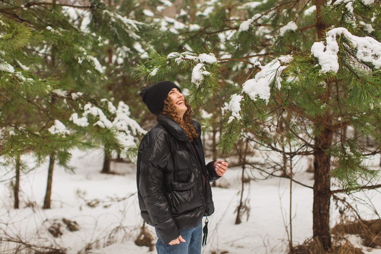 redhead woman in the woods wearing a puffer jacket