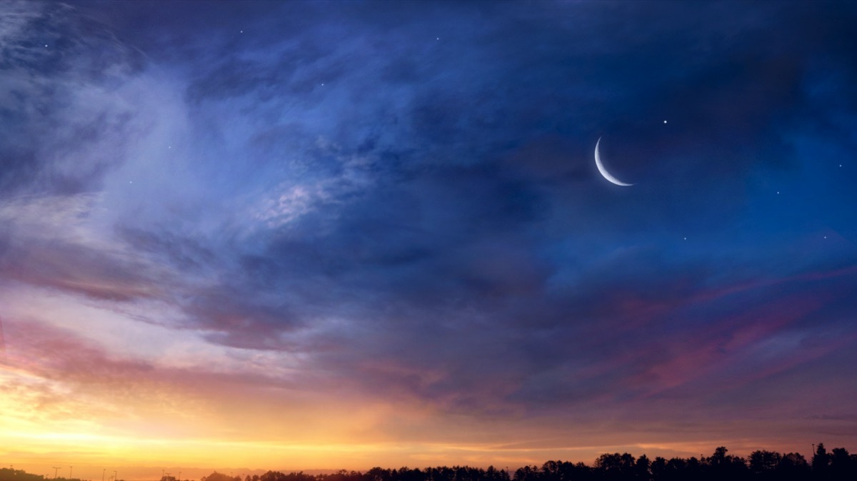 Crescent moon against sunset