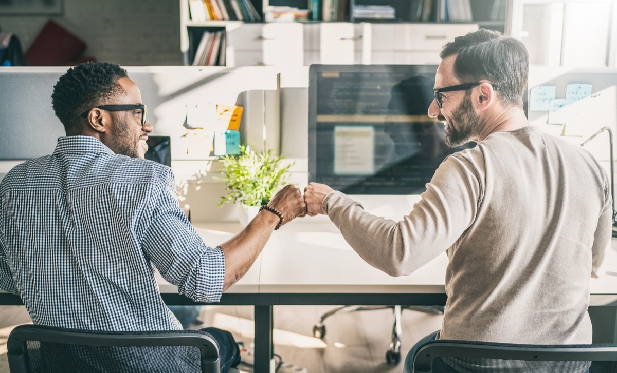 First bump between colleagues at work. Success in business. Everyday work in the office.