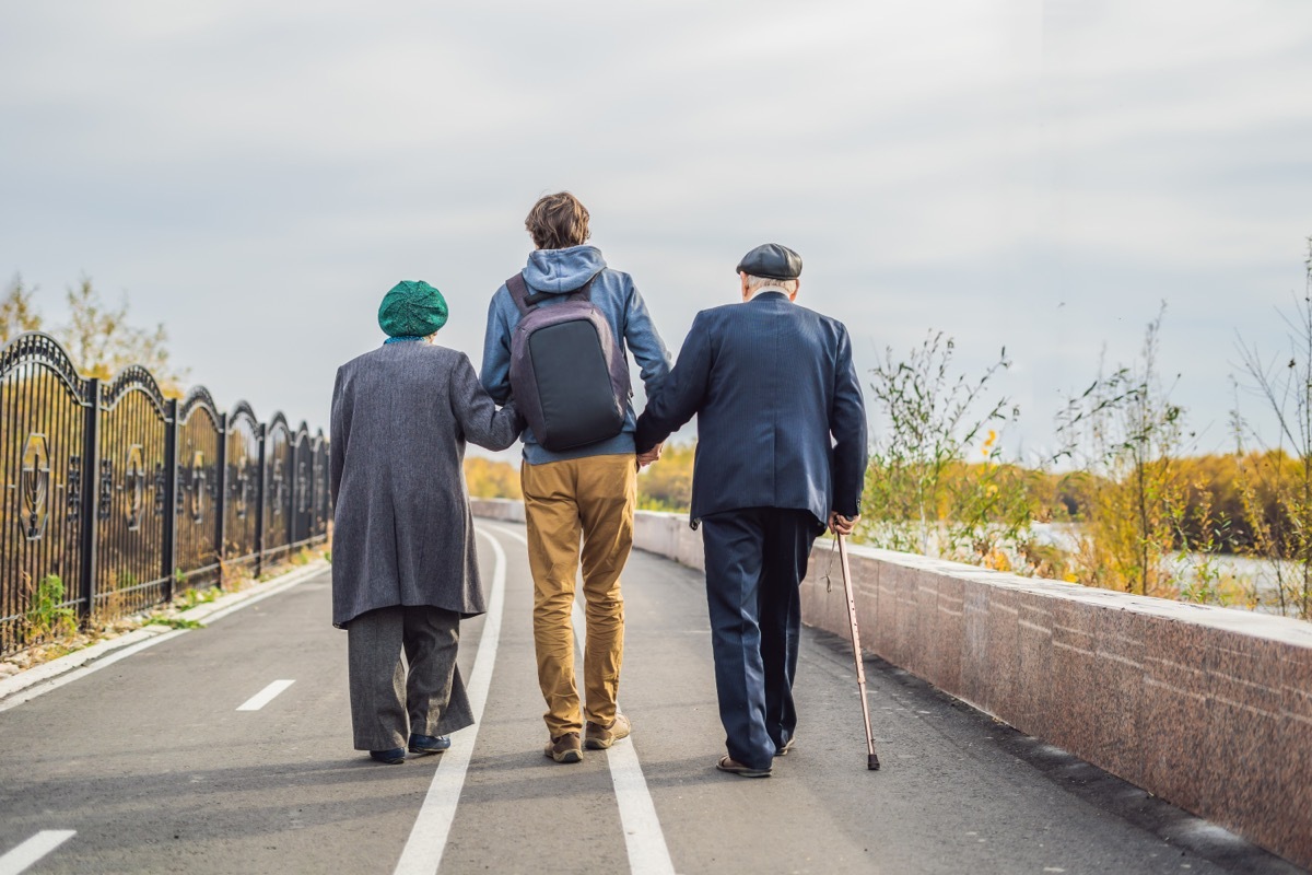 kind young man helping elderly couple