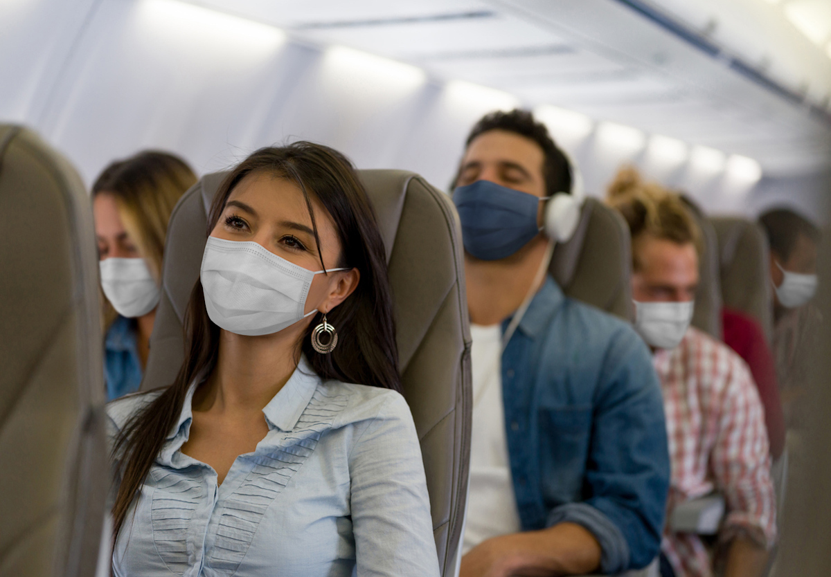 Travelers on a plane wearing face masks during the COVID-19 pandemic